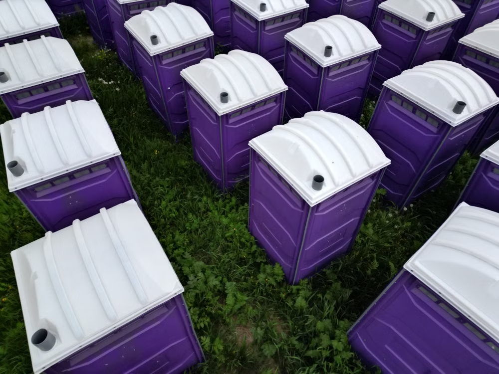 grid of purple porta potties on a field