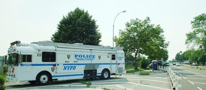 John to Go portable bathroom rental in NY near an NYPD truck