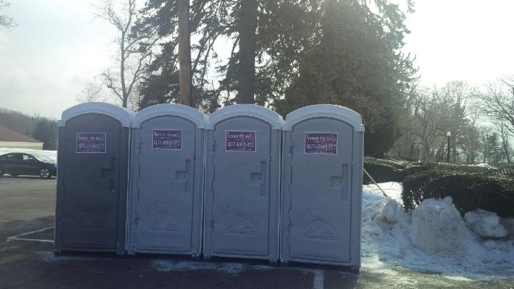 row of porta potties in winter snow