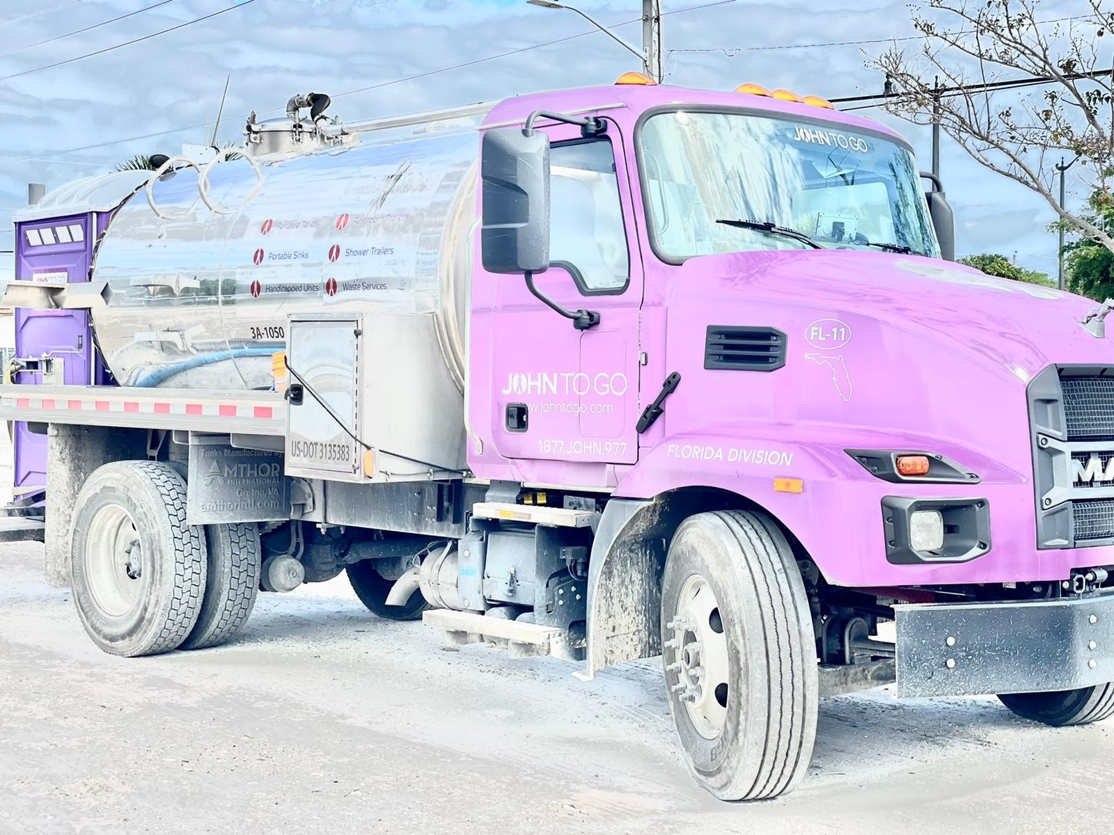 john to go service truck carrying a porta john restroom unit