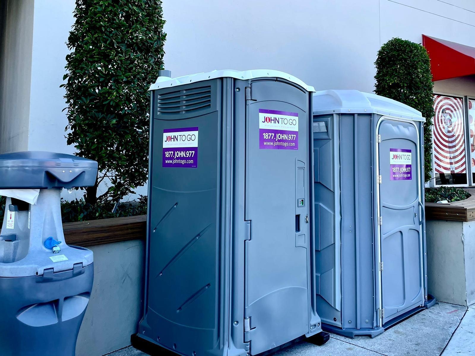 Porta potty restrooms and handwashing station near storefront