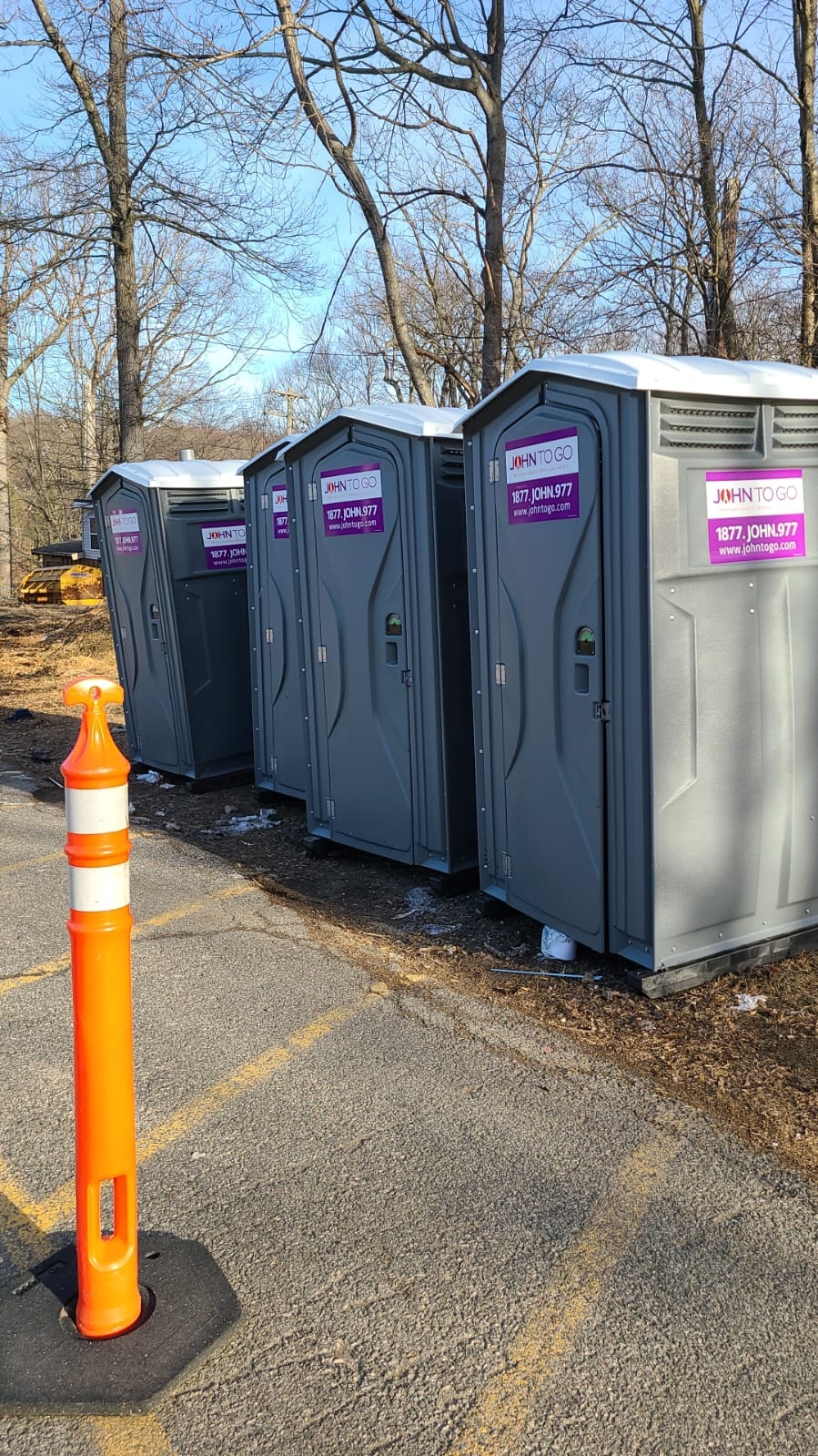 3 gray porta john rental units