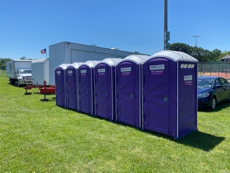 Row of purple porta potty stalls in Newark, NJ