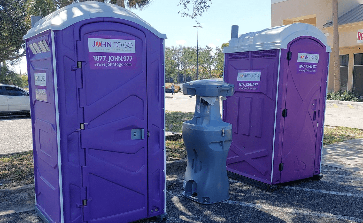 Portable hand washing station between porta potties at outdoor event