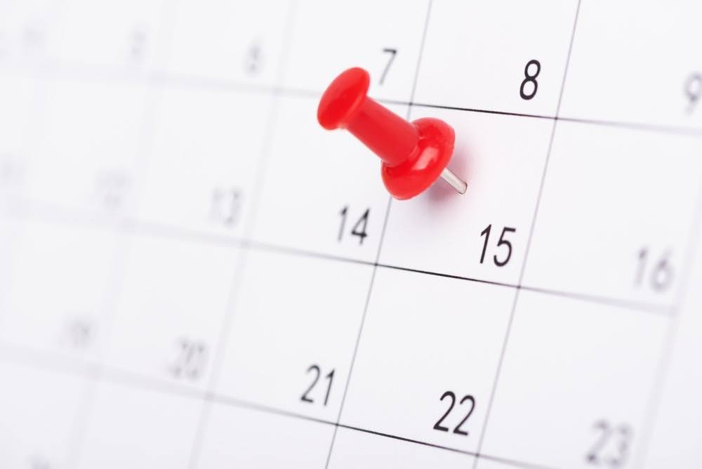 close-up of a calendar with a pushpin on a date