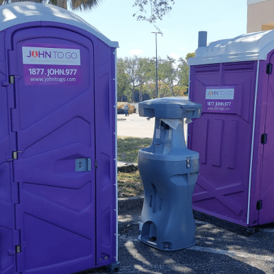 Portable hand washing station between porta potties at outdoor event